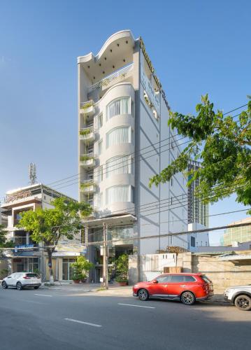 a red car parked in front of a building at Thanh Lan Riverside Hotel Da Nang in Danang