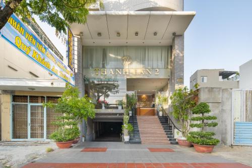 a building with potted plants in front of it at Thanh Lan Riverside Hotel Da Nang in Danang
