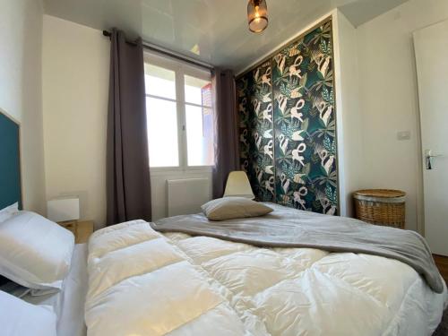 a bedroom with a large bed and a window at Chez Banane - Futuroscope - LaConciergerie in Jaunay-Marigny