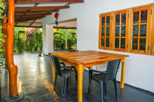 - une table et des chaises en bois dans l'établissement Sigiri Sandilu Homestay, à Sigirîya