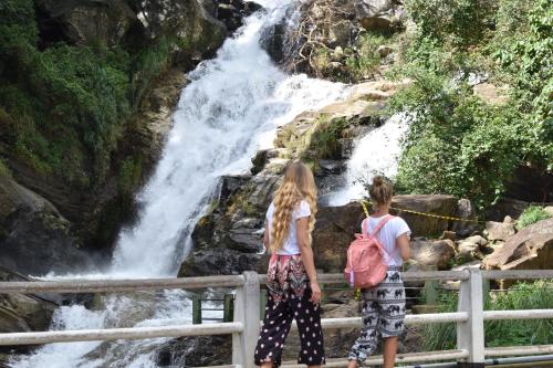 two girls standing on a fence looking at a waterfall at Forest Edge Safari Villa in Udawalawe