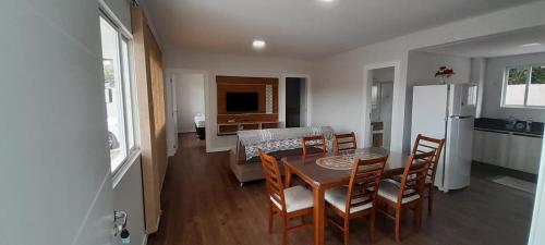 a kitchen and dining room with a table and chairs at Apartamento Ponta do Papagaio - Térreo in Palhoça