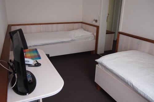 a room with two beds and a computer on a desk at Landhaus Wesermarsch in Achim