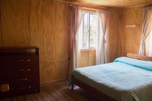 1 dormitorio con 1 cama, vestidor y ventana en Refugio La Rinconada, en Bahía Murta