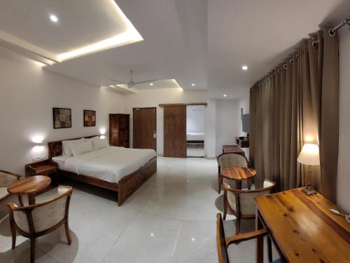 una camera d'albergo con letto, tavolo e sedie di Aura Gold Resort a Udaipur