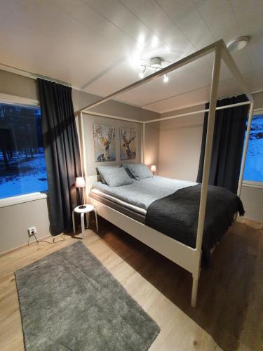 a bedroom with a canopy bed and a large window at Väre Holiday Home - lakeside relaxation point in Inari