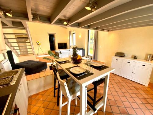 uma cozinha com mesa e cadeiras num quarto em LA BERGERIE DU DAMIAN em Neuville