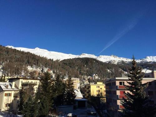 a group of buildings and a mountain with snow at Chesa Derby 32 in St. Moritz
