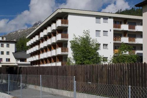 un edificio de apartamentos blanco con una valla delante en Chesa Derby 32, en St. Moritz