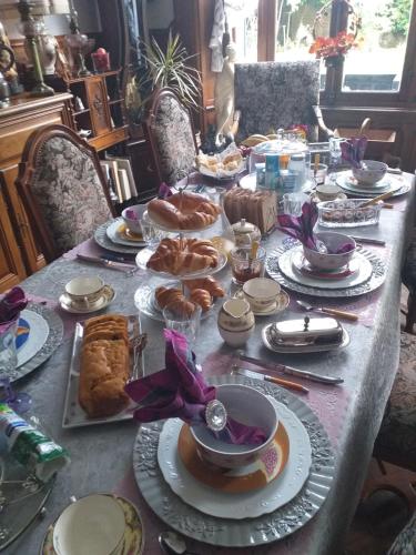 VILLA LES CAMELIAS في Fontaine-lès-Vervins: طاولة طويلة عليها أطباق من الطعام