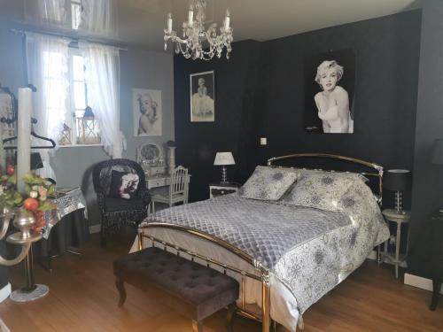 een slaapkamer met een bed en een tafel en stoelen bij VILLA LES CAMELIAS in Fontaine-lès-Vervins