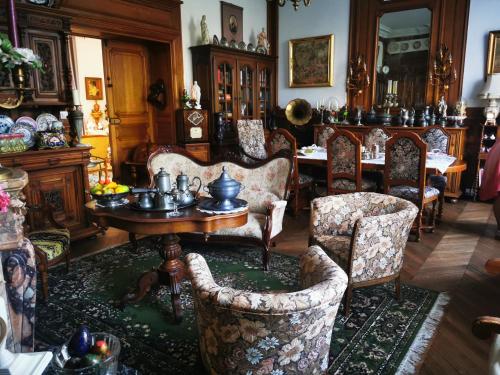 un salon avec une table et des chaises et une salle à manger dans l'établissement VILLA LES CAMELIAS, à Fontaine-lès-Vervins