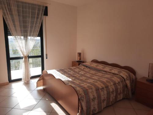 een slaapkamer met een bed en een groot raam bij La Rosa dei Venti Apartments in Eboli
