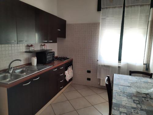 een keuken met een wastafel en een aanrecht bij La Rosa dei Venti Apartments in Eboli