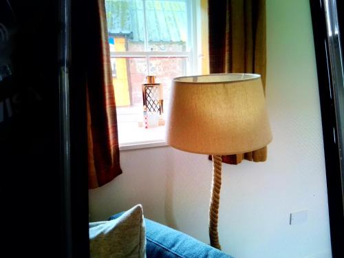 a lamp sitting in a room next to a window at The Wee Anchor in Arbroath