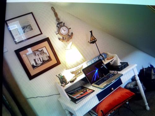 una scrivania con computer portatile e un orologio appeso a una parete di The Wee Anchor ad Arbroath
