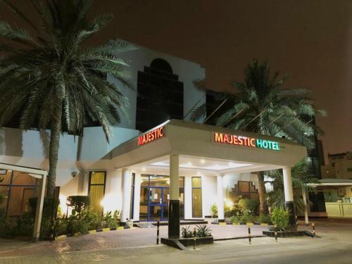 a masestation hotel with palm trees in front of it at Majestic Hotel in Manama