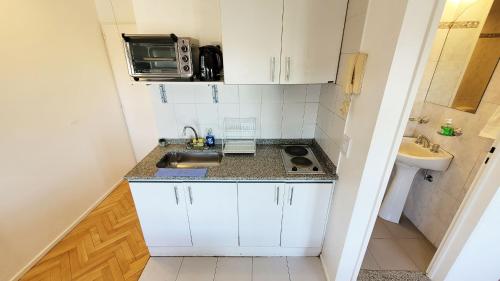 a small kitchen with a sink and a microwave at Studio Uriarte Palermo Soho in Buenos Aires
