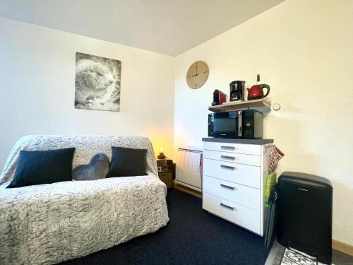 a bedroom with a bed and a dresser and a clock at L'AnsloBoys Montagne L2 in Les Deux Alpes