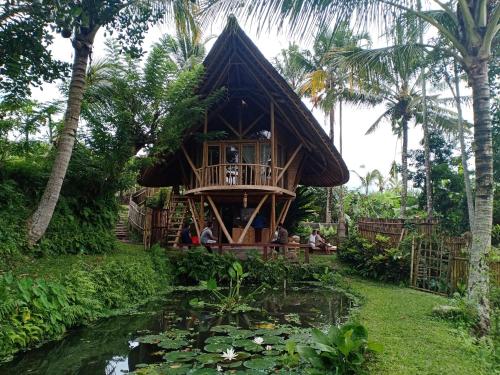 a tree house with a pond in front of it at Jero Tumbuk Private Villa in Selat