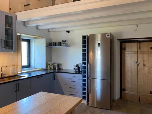 a kitchen with a stainless steel refrigerator and a wooden table at Casa do Vale in Marvão