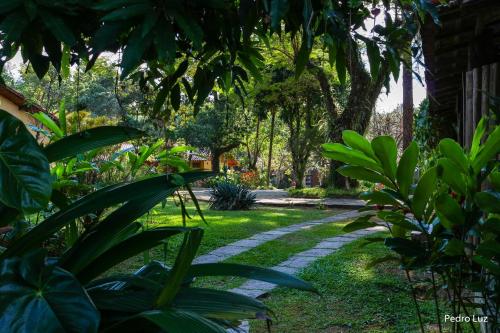 a path in a garden with green plants and trees at Pousada Villa Luna in Penedo