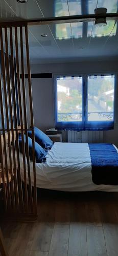 Bett in einem Zimmer mit 2 Fenstern in der Unterkunft Aux 77 Nuitées in Trilport