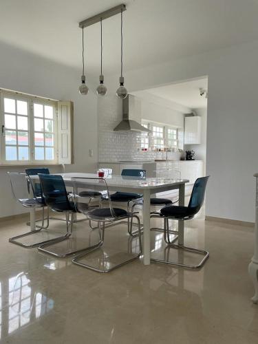 a kitchen with a dining table and chairs at Ericeira -Oceonview Villa with Pool and Whirlpool in Ericeira