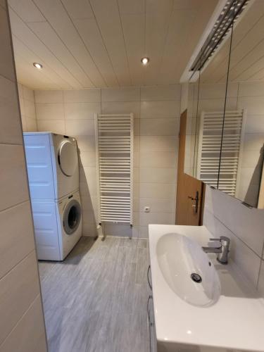 y baño con lavabo y lavadora. en Ferienwohnung Neubörger mit Hottub, en Neubörger