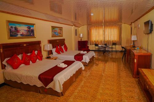 a hotel room with two beds with red pillows at Metro Hotel Couva in Couva