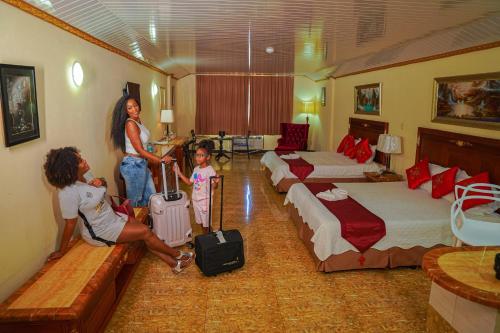 two women and a little girl in a hotel room at Metro Hotel Couva in Couva