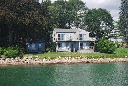 a white house on the shore of a body of water at Dockside Guest Quarters in York