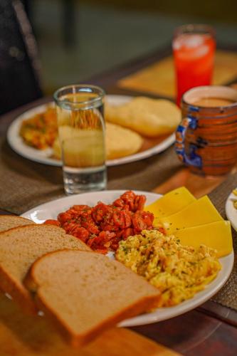 two plates of food on a table with eggs and bread at Metro Hotel Couva in Couva