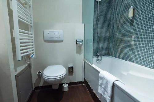 a bathroom with a toilet and a tub and a sink at Appart'City Classic Lyon Part-Dieu in Lyon