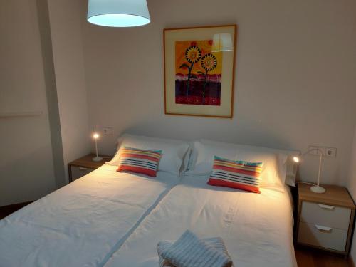 a bedroom with a white bed with two pillows at Ventura Apartment ESS02622 in Donostia-San Sebastián