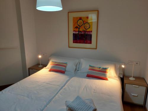 1 dormitorio con 1 cama blanca y 2 almohadas en Ventura Apartment ESS02622, en San Sebastián
