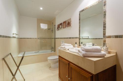 a bathroom with a sink and a toilet and a tub at Arcos Gardens Sol Rent Golf in Arcos de la Frontera