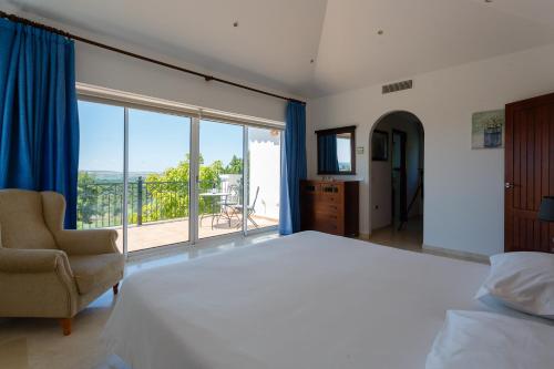 a bedroom with a large bed and a large window at Arcos Gardens Sol Rent Golf in Arcos de la Frontera