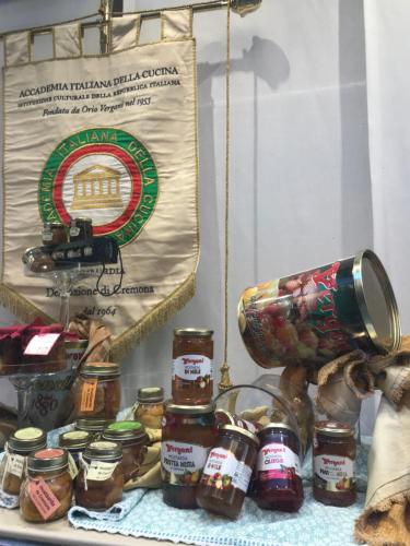 a table topped with jars of jam next to a sign at Alloggio Galli in Cremona