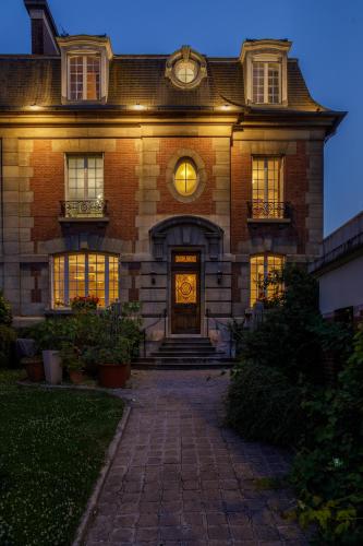 a large brick house with a door with lights on it at L'Hôtel Particulier - Paris Asnières in Asnières-sur-Seine