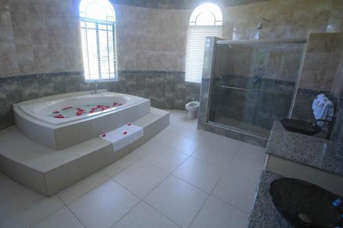 ein Badezimmer mit großer Badewanne und Dusche in der Unterkunft Luxury 10 Bedroom Villa-Millbrooks in Montego Bay