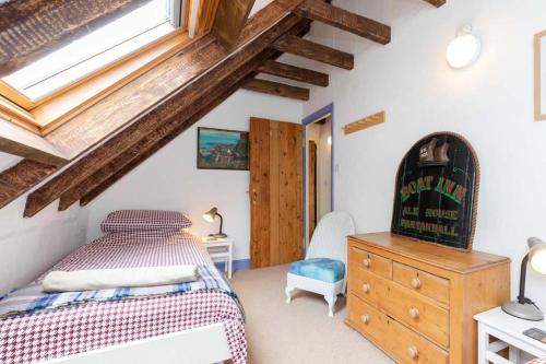 a bedroom with a bed and a dresser and a window at The Cottage By The Sea, Scotland in Burnmouth