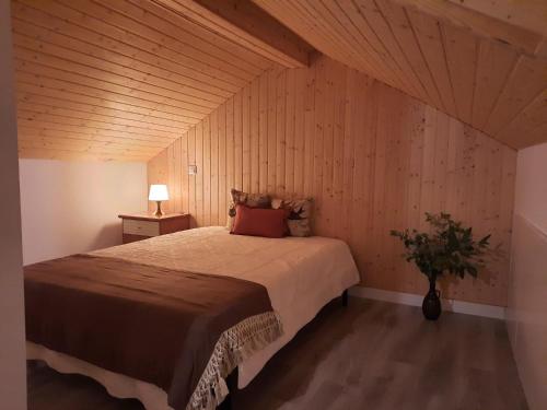 a bedroom with a large bed with a wooden ceiling at A CASA DA VILA in Ermidas