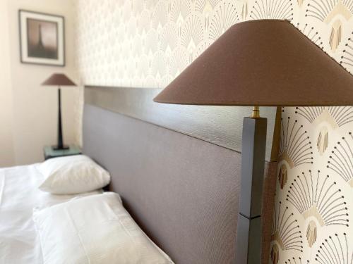 a hotel room with a bed and a lamp at La Villa Paris - B&B in Paris