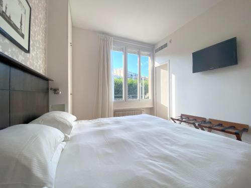 a bedroom with a large white bed with a window at La Villa Paris - B&B in Paris