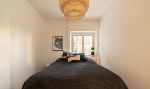 1 dormitorio con 1 cama con manta negra en ULEABO New, Light and Roomy 61m² Apartment With Sauna!, en Oulu