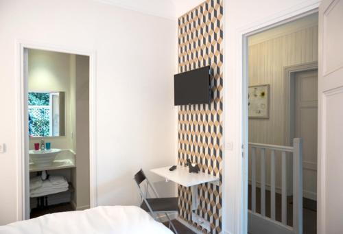 a bedroom with a bed and a sink and a mirror at La Villa Paris - B&B in Paris