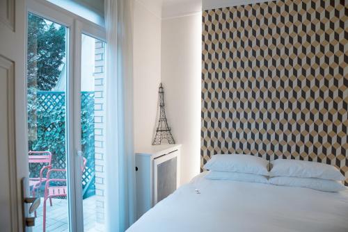 a bedroom with a bed and a large window and a balcony at La Villa Paris - B&B in Paris