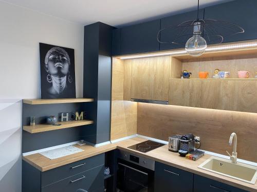 a kitchen with blue cabinets and a sink at Arletti Luxury Apartment in Ruse