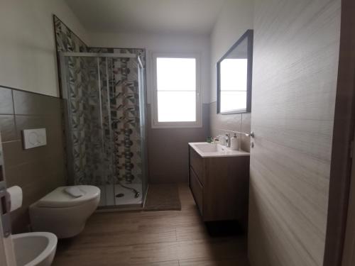 a bathroom with a shower and a toilet and a sink at Abaton - Casa vacanza in Metaponto